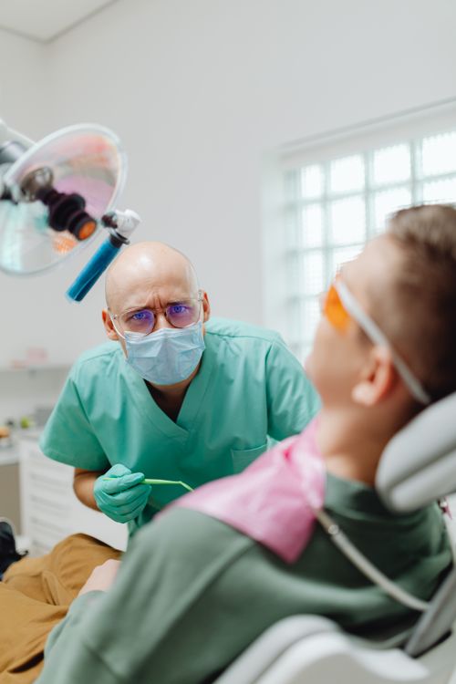 Free A dentist in a clinic providing dental care to a patient wearing safety glasses. Stock Photo