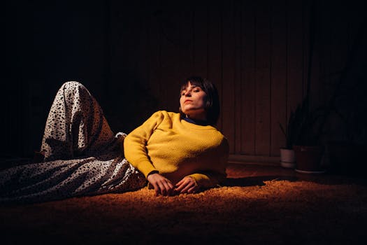 A woman in a yellow sweater reclines indoors, creating a warm, stylish scene.