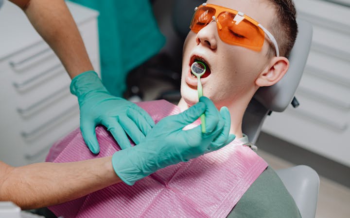 A young adult receives dental treatment at a modern clinic, showcasing oral hygiene practices.