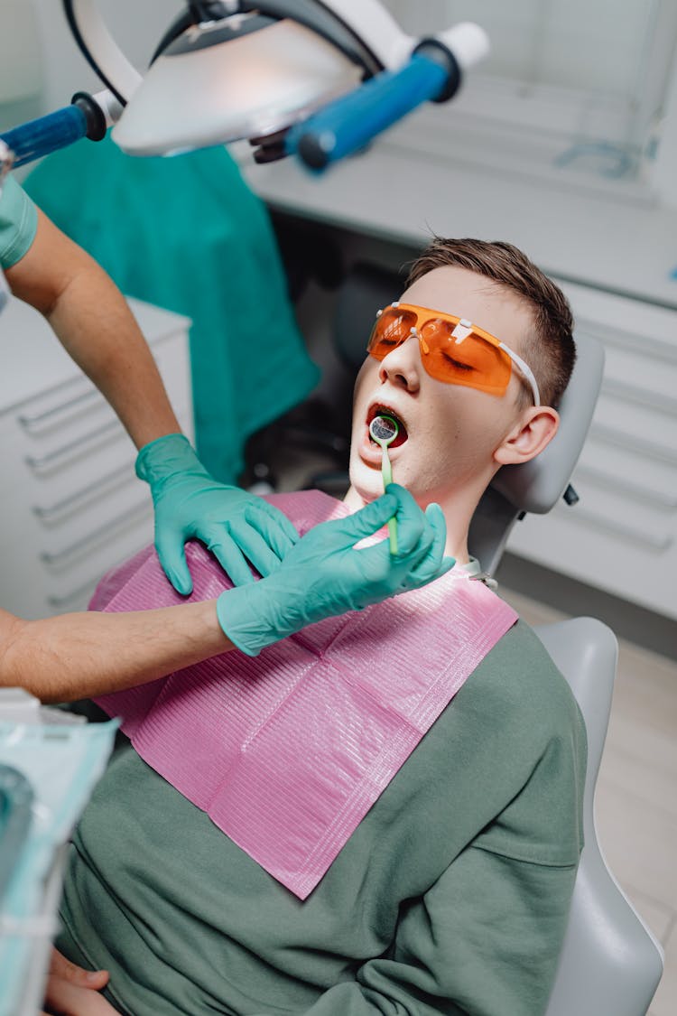 Dentist Curing Patient Teeth In Clinic