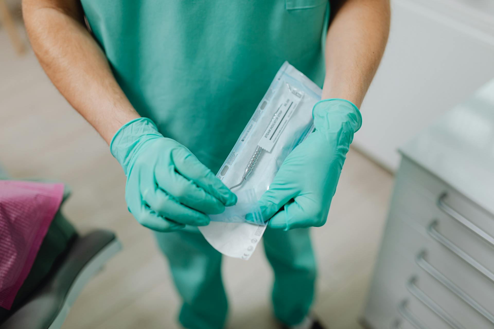 Doctor in Rubber Gloves Unpacking Sterile Instruments