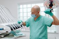 Man in Teal Scrub Suit Holding Medical Tools and Equipment