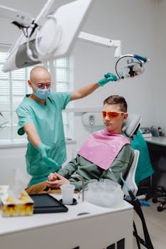 Patient in dental clinic wearing protective glasses during consultation with a dentist.