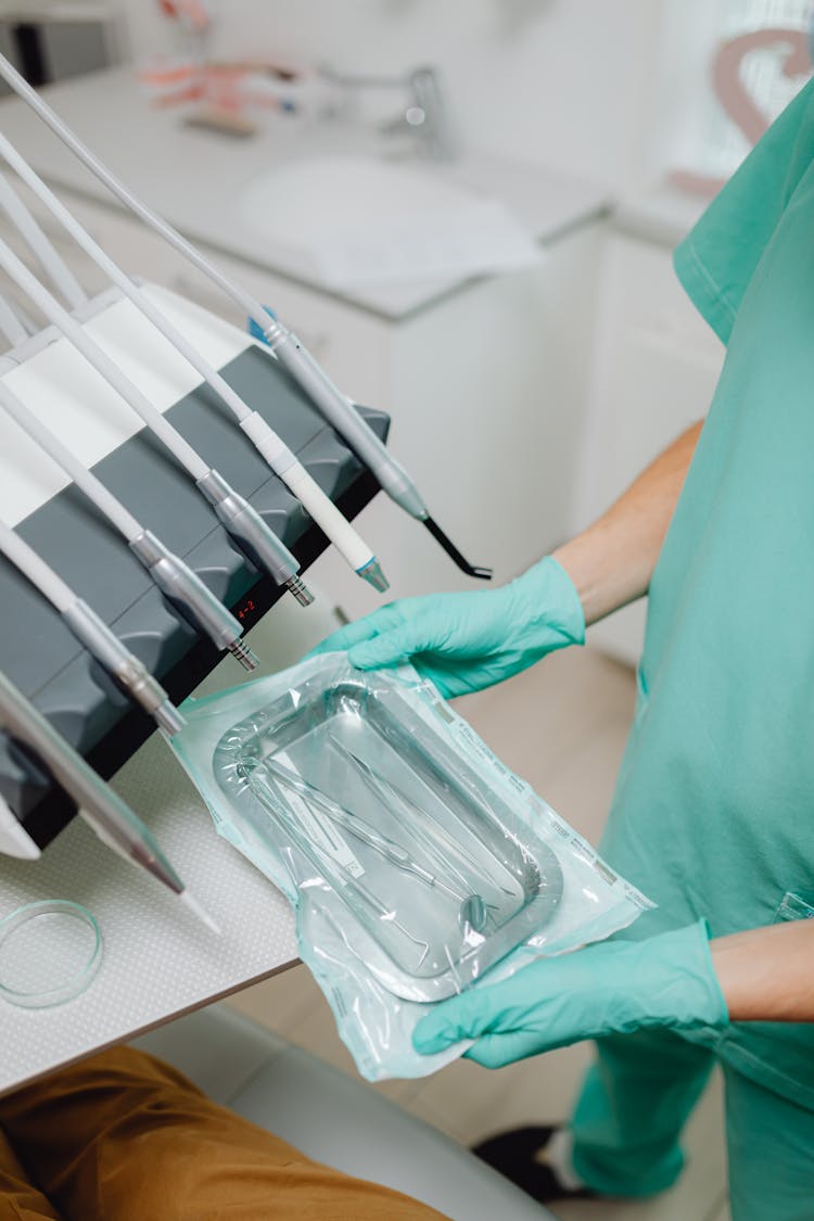 Dentist With Sterile Instruments In Cabinet