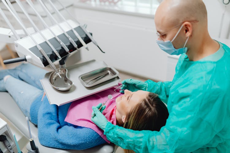 A Dentist Examining A Woman On A Dental Chair