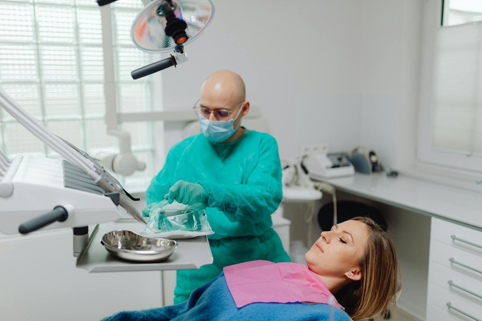 A Dentist Opening a Pack of Sterilized Medical Instruments