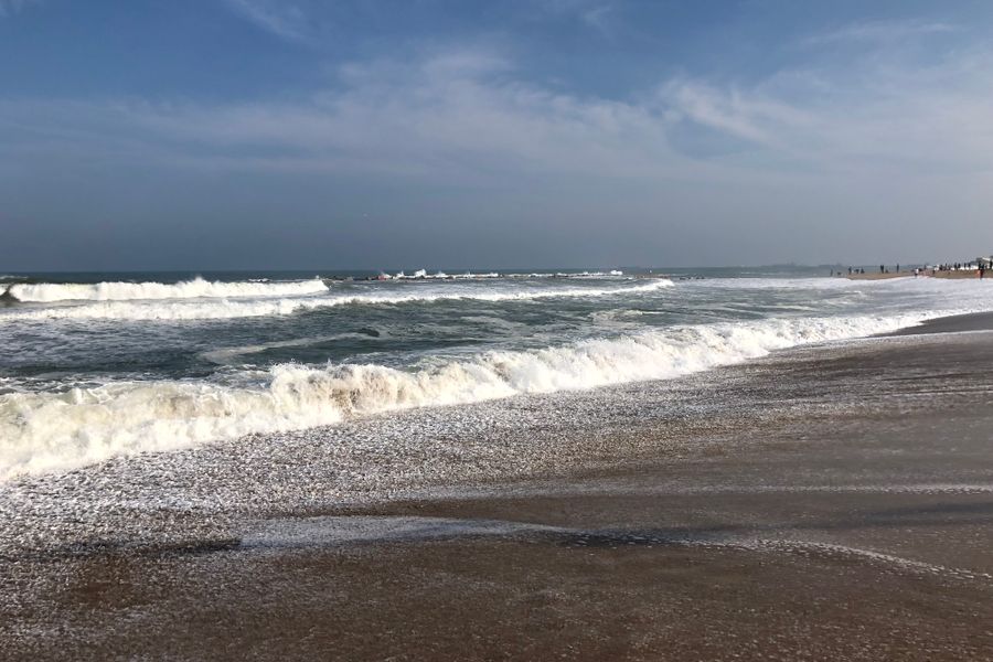 Vibrant beach scene with crashing ocean waves and a tranquil horizon.