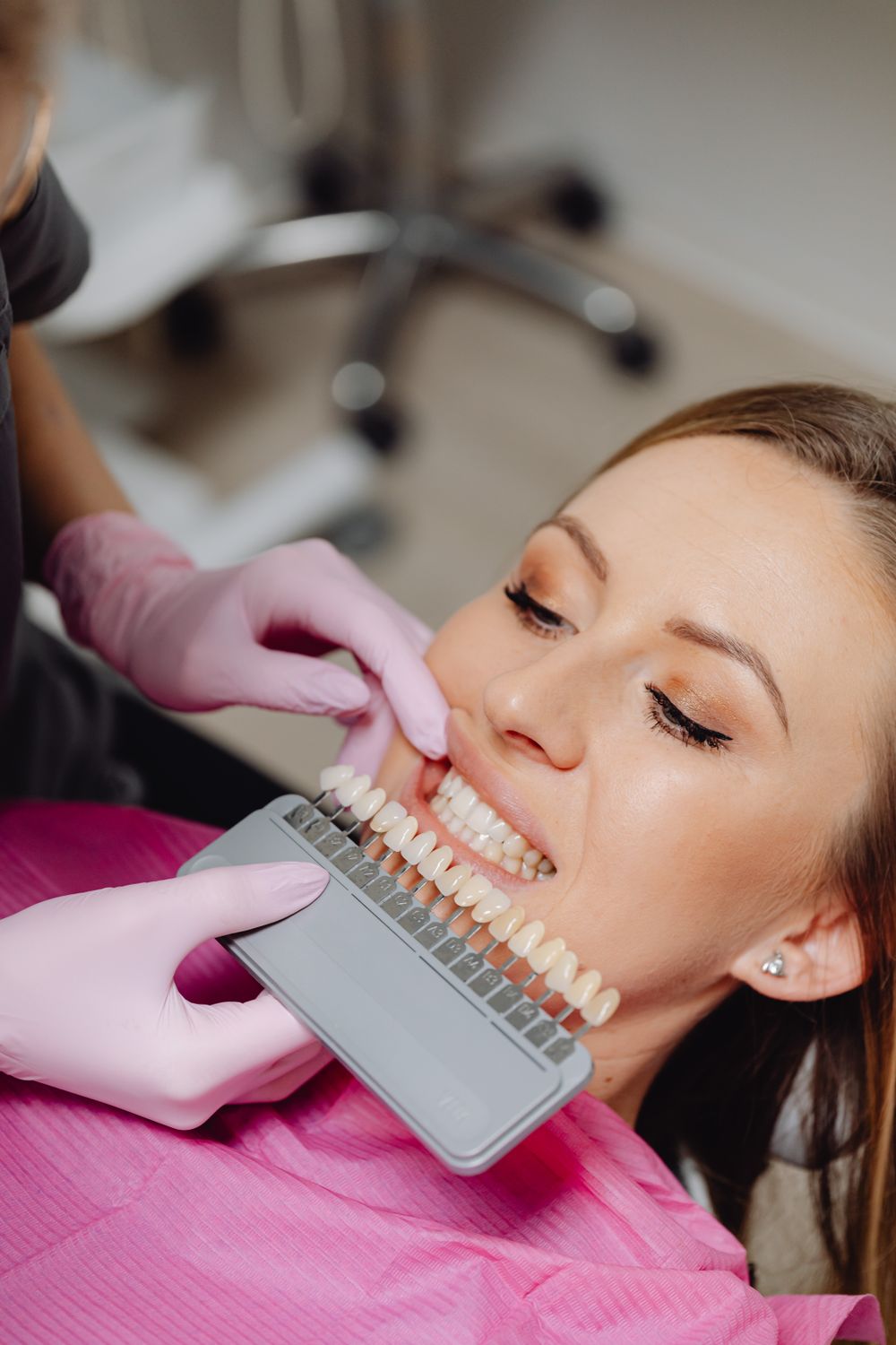 A dentist matching a veneer shade to a patient's smile