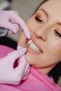 A Dentist Applying a Veneer Tooth on a Patient