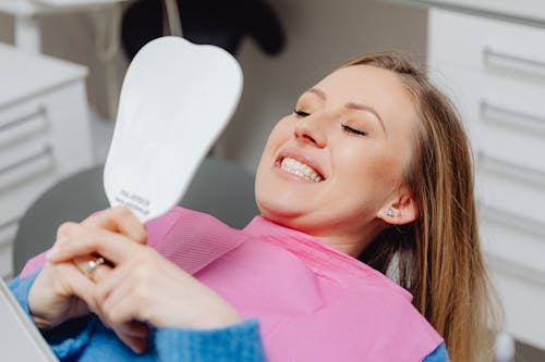 Free Smiling Woman in Dentist Chair Looking in Mirror  Stock Photo