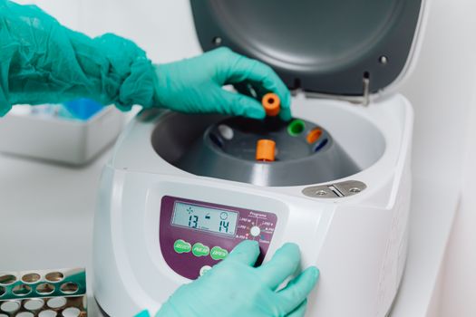 A close-up of a lab technician using a centrifuge to process blood samples in a medical laboratory. — photo by www.kaboompics.com