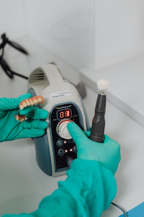 
A Close-Up Shot of a Person Wearing Latex Gloves Operating a Medical Equipment