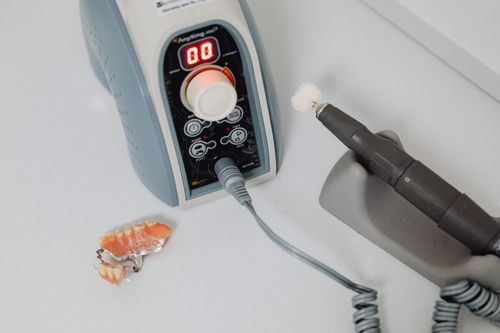 Free Close-up of dental machine and denture on countertop, showcasing dental technology. Stock Photo