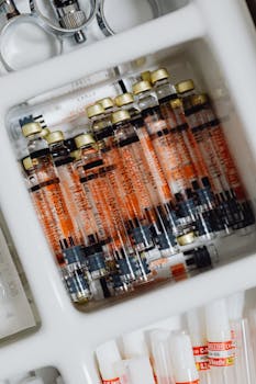 Close-up of organized medical syringes and vials in a drawer, showcasing precise arrangement.
