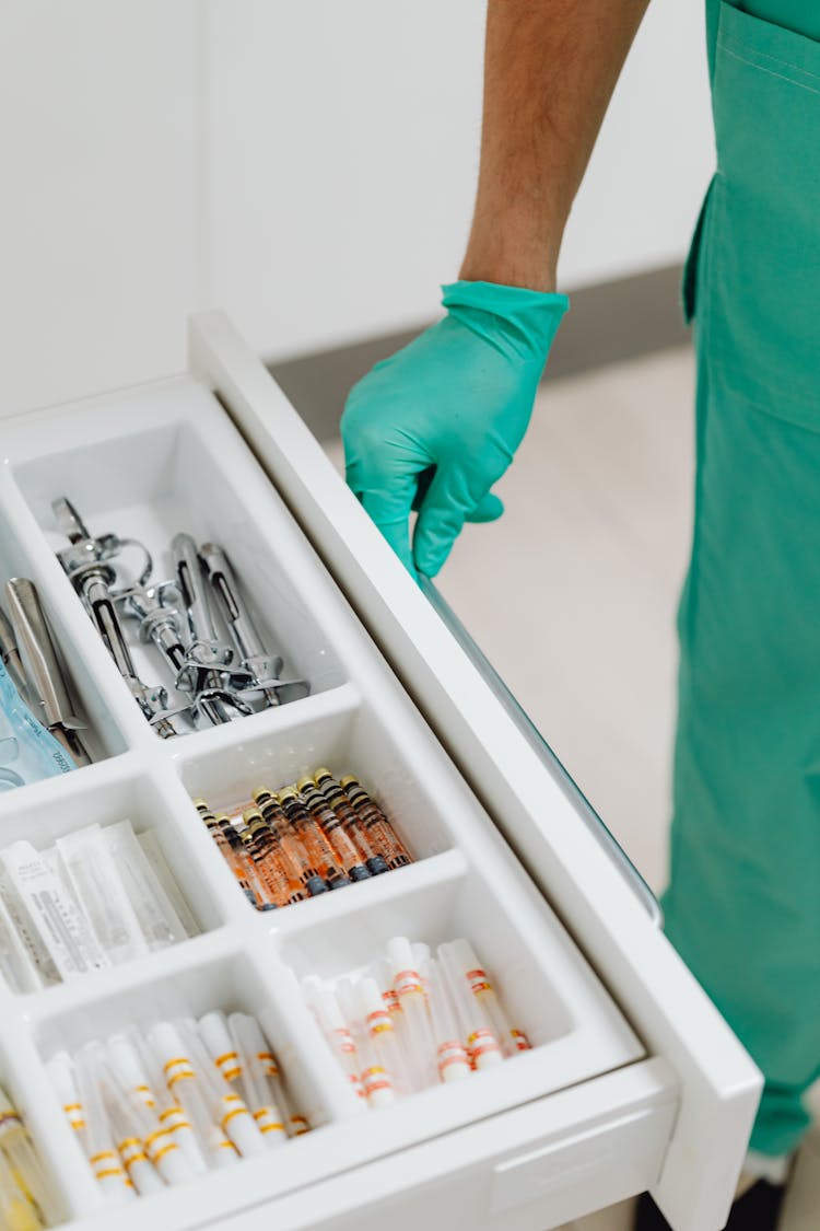 A Doctor Opening A Drawer With Medical Tools 