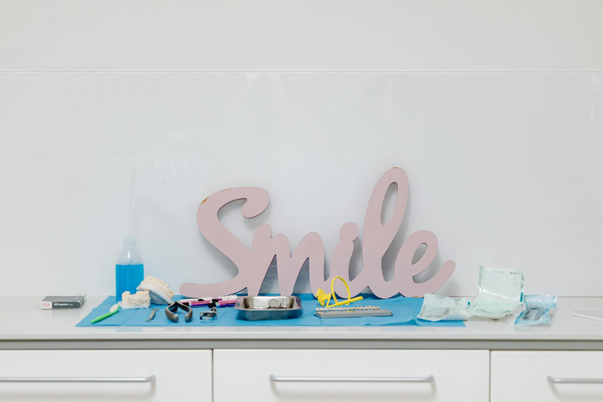 Dental tools and 'Smile' sign in a modern dental office setting, emphasizing oral health care.