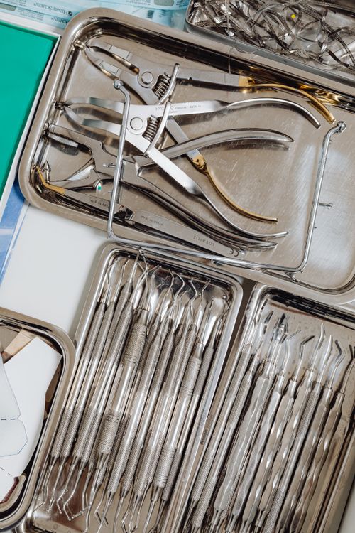 Free Close-up of organized dental instruments in stainless steel trays, ideal for medical use. Stock Photo
