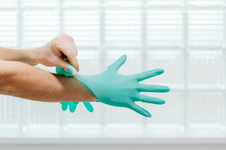 Close Up Of Doctor Hands Putting On Gloves