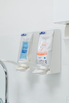 Close-up of hygienic hand sanitizer dispensers in a dental clinic.