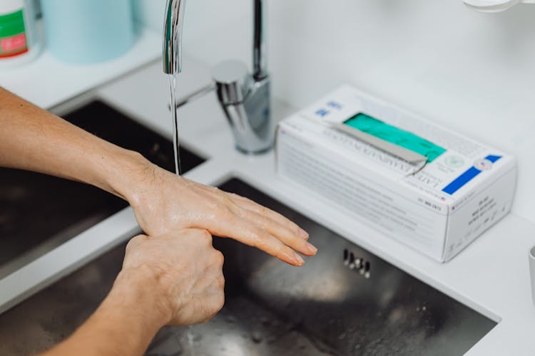 Doctor Washing Hands Under Tap Water