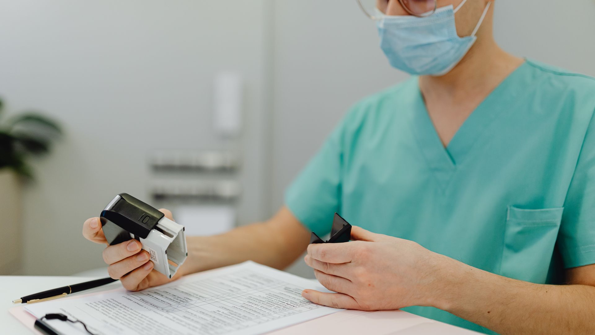 Wakealert Modafinil Review: Unlocking Focus and Productivity Healthcare worker in scrubs reviewing patient files with a stamp and clipboard.