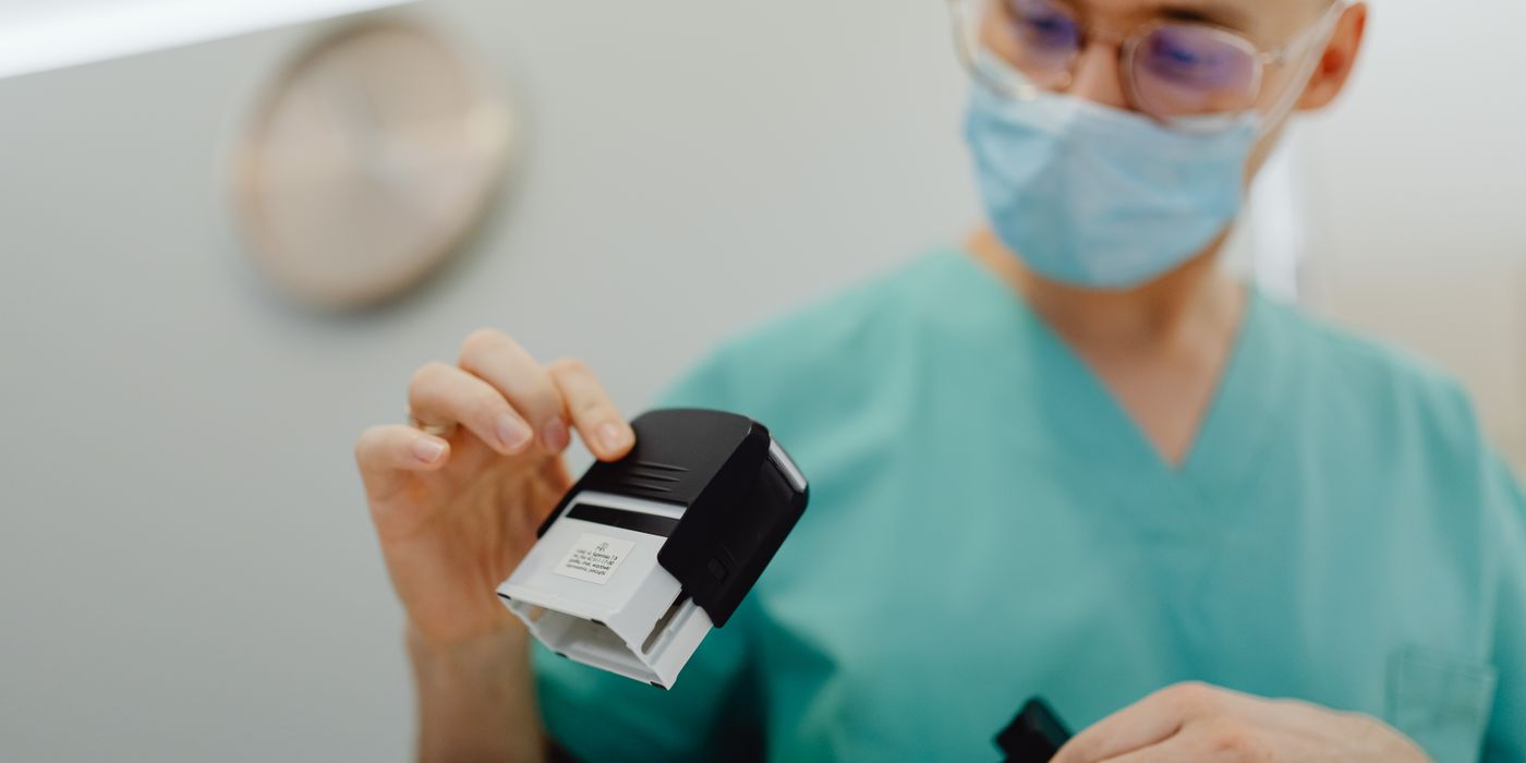 Healthcare worker stamping documents in a clinic setting, ensuring efficient workflow.