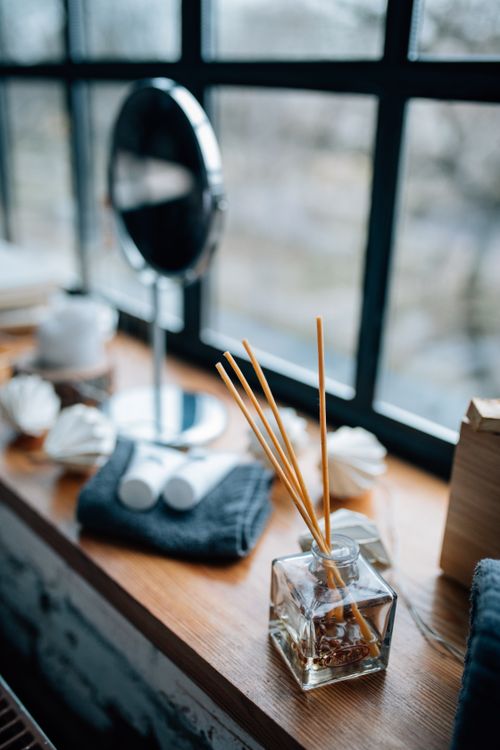 Free Elegant setup of a reed diffuser and accessories by a window. Stock Photo