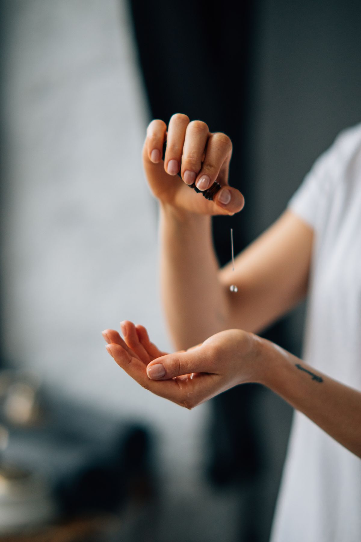 A person pouring body serum onto their hand before massaging it in