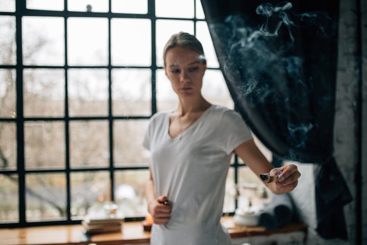 A Woman Holding A Sage With Smoke