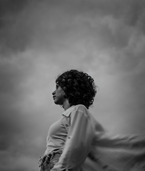 Low Angle Shot of a Woman on the Background of a Cloudy Sky 