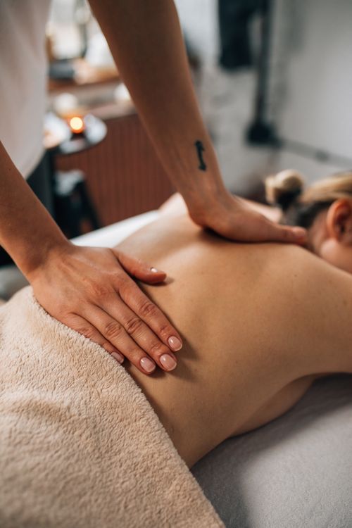 Free Close-up of hands massaging a person's back in a tranquil spa setting, promoting relaxation and wellness. Stock Photo