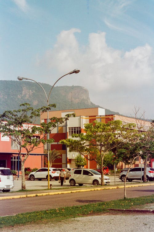 People Walking on Street Near Cars Parked Beside Building