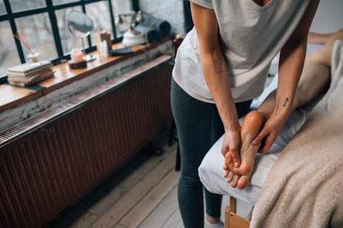 A Woman Massaging a Person's Foot