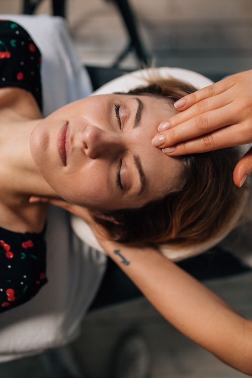 Free Woman receiving a soothing facial massage for ultimate relaxation and self care in a spa setting. Stock Photo