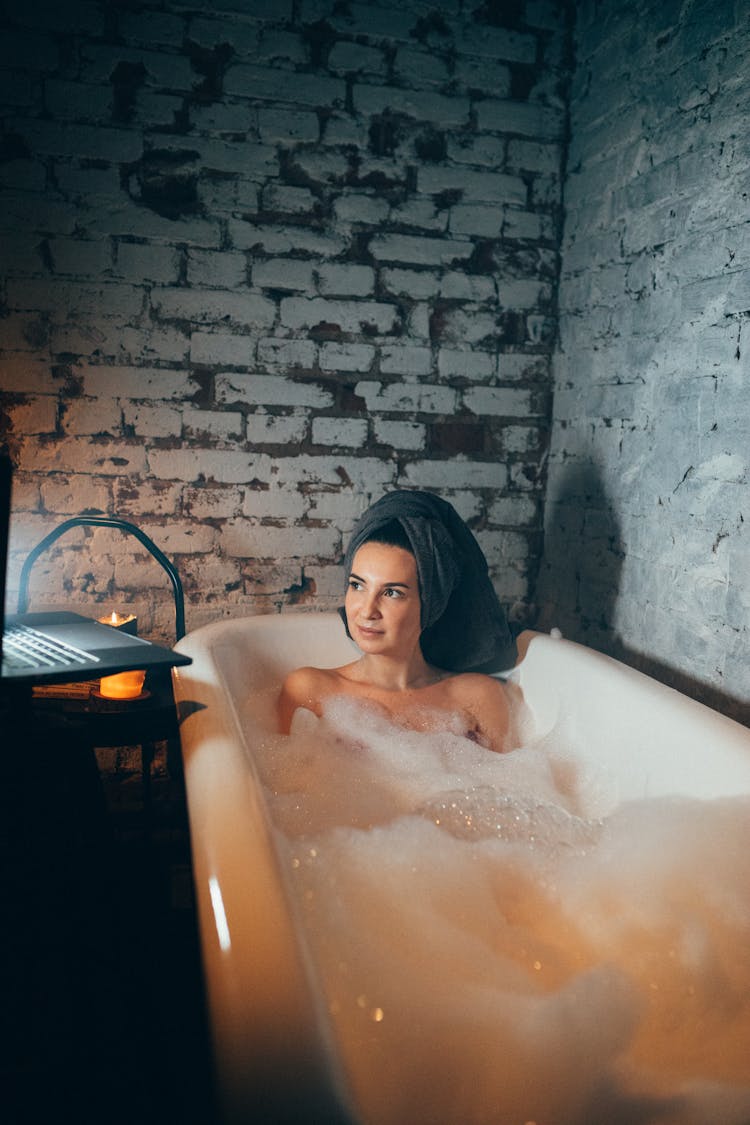 Woman In Bathtub Covered With Bubbles