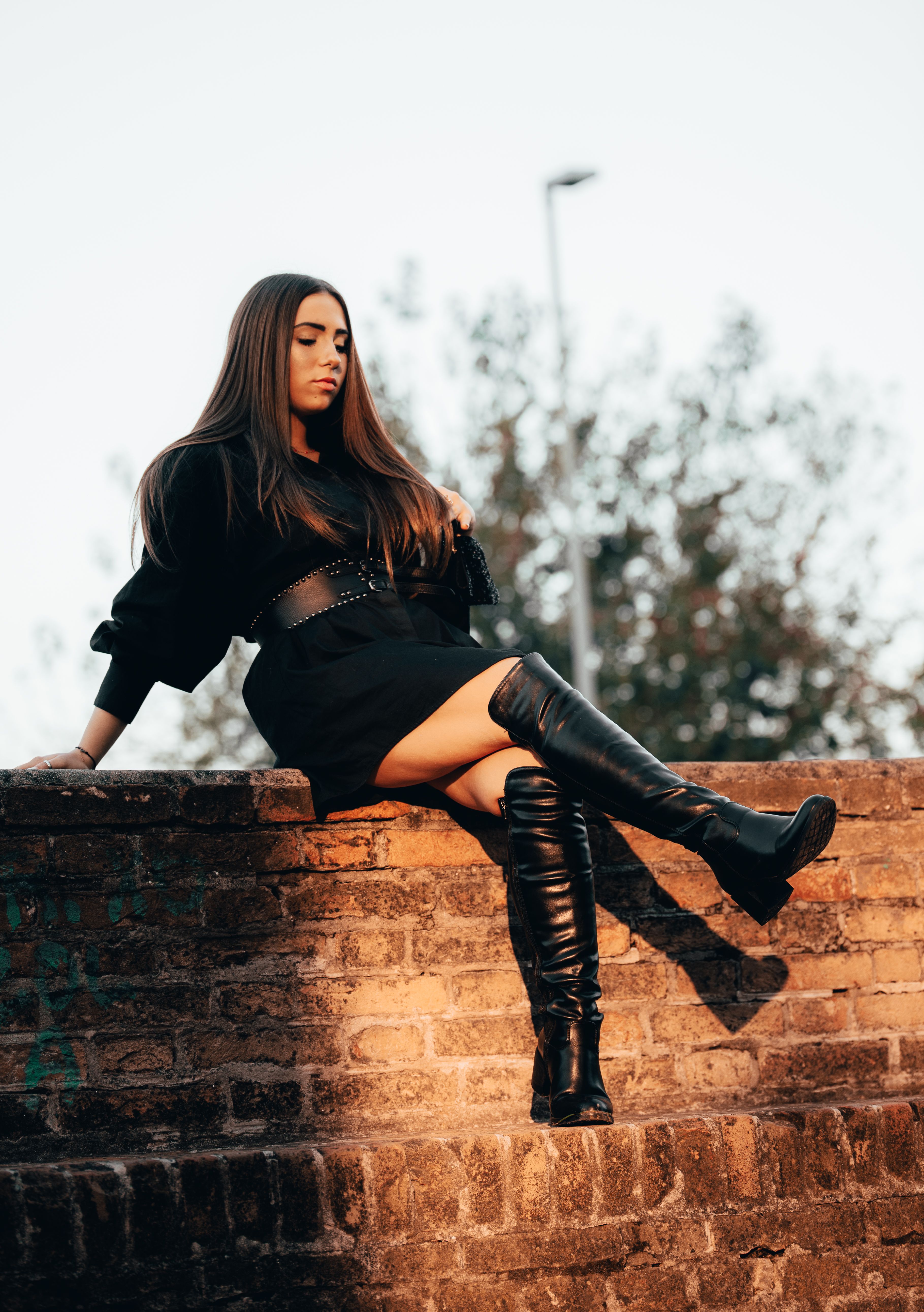 Fashionable woman posing on a brick wall in Mantova, Italy outdoors.