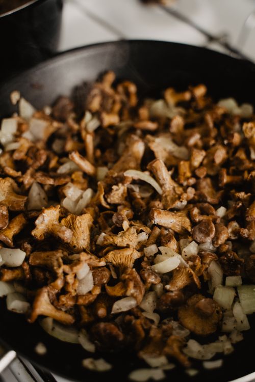 Free Delicious stir fry of chanterelle mushrooms and onions cooked to perfection, ideal for culinary presentations. Stock Photo
