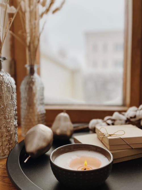 Lighted Candle Beside Boxes