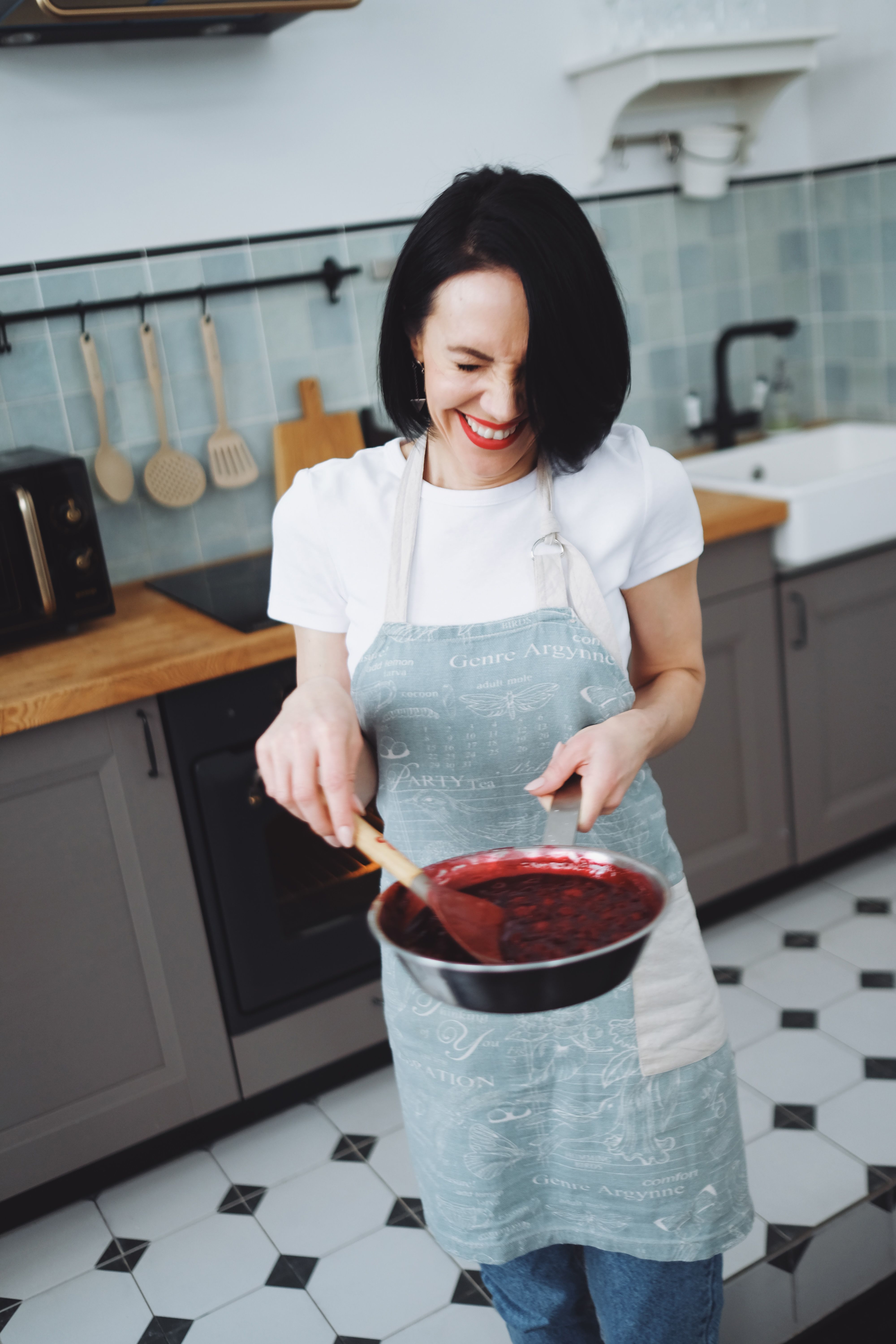 Woman in an Apron Holding a Pan and a Ladle · Free Stock Photo