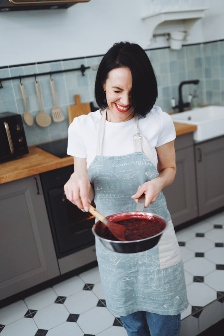 Woman In An Apron Holding A Pan And A Ladle