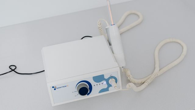 Profissional de estética avançada preparando equipamento certificado para tratamento de renovação facial em consultório.