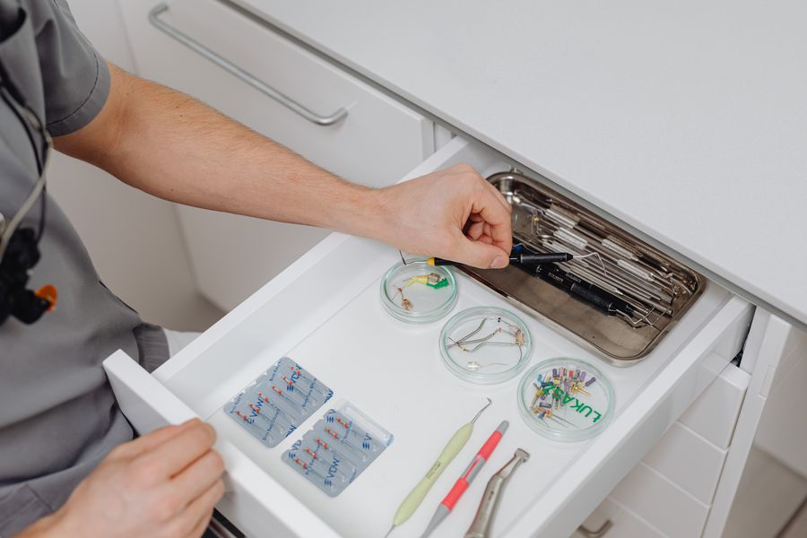 Close-up of a dental professional organizing tools in a drawer.