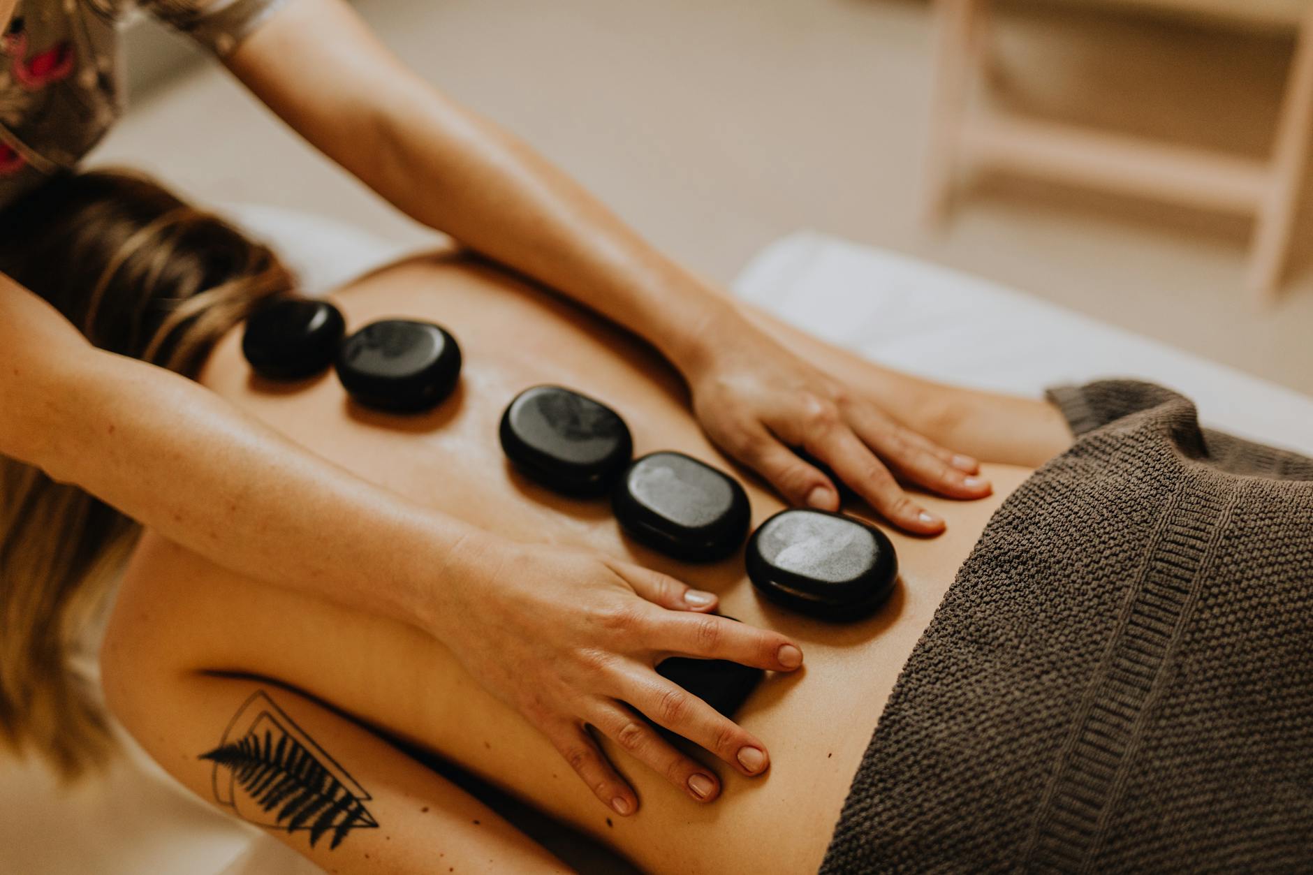 https://www.pexels.com/photo/woman-having-a-massage-with-massage-stones-6629521/