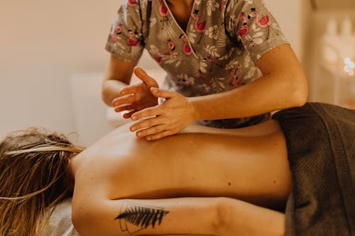 Free A Tattooed Woman Having a Massage Stock Photo