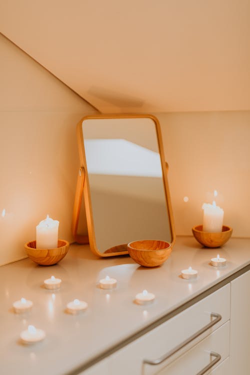 Free Mirror and White Candles on White Wooden Table Stock Photo