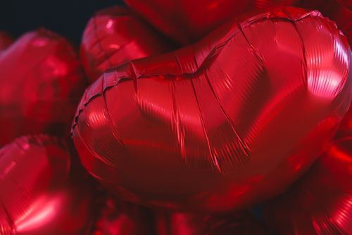 Free Vibrant heart-shaped red balloons perfect for Valentine's themed backgrounds. Stock Photo