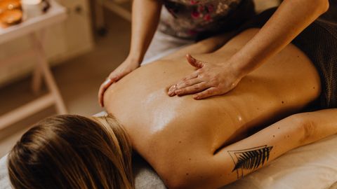 A serene spa setting captures a relaxing back massage, enhancing wellness.