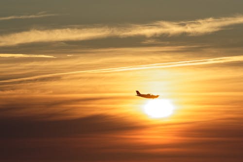 Silhouette of an Airplane Flying during Sunset