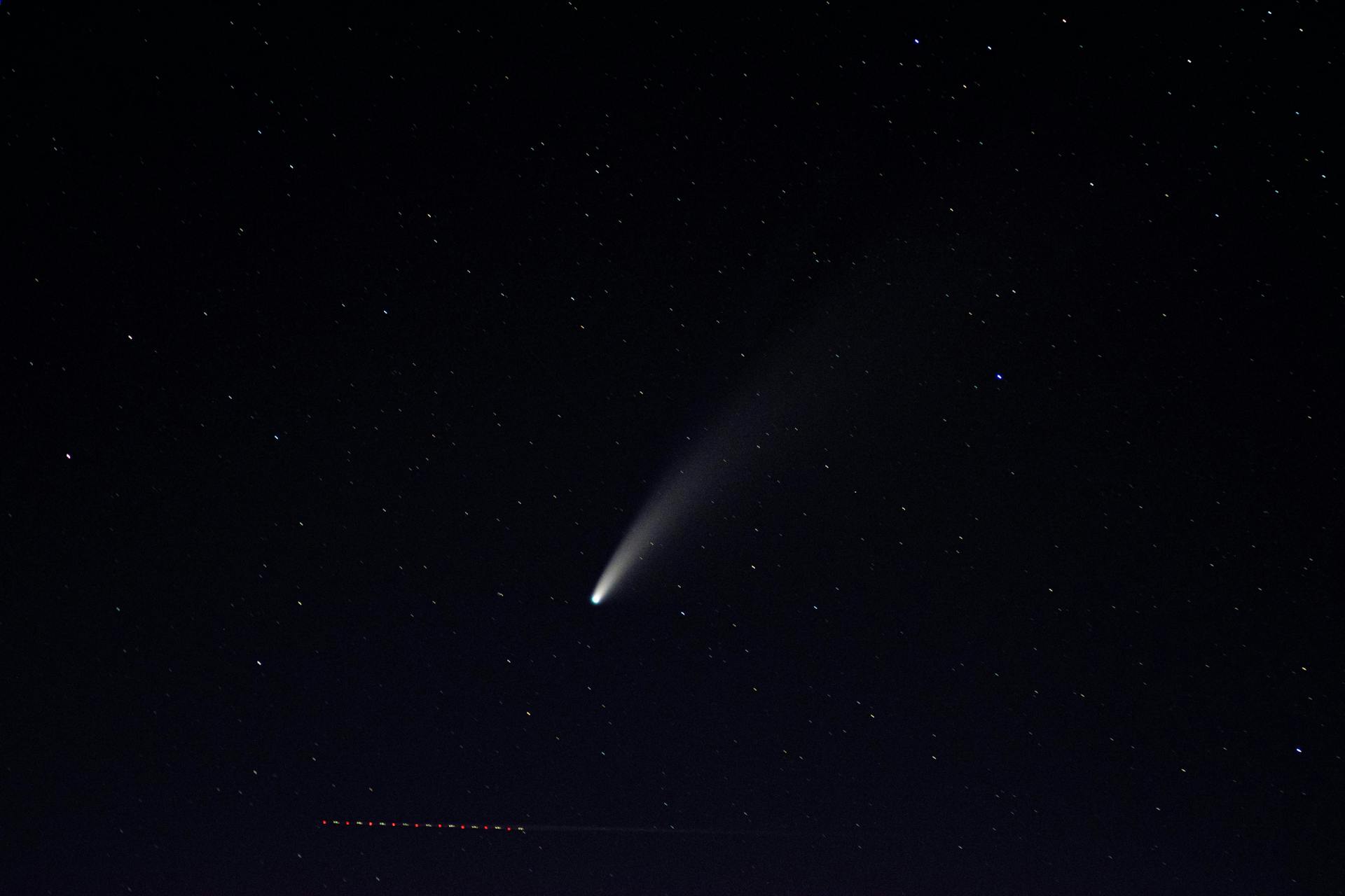 Captured under Airolo's night sky, a bright comet and stars create a celestial spectacle.