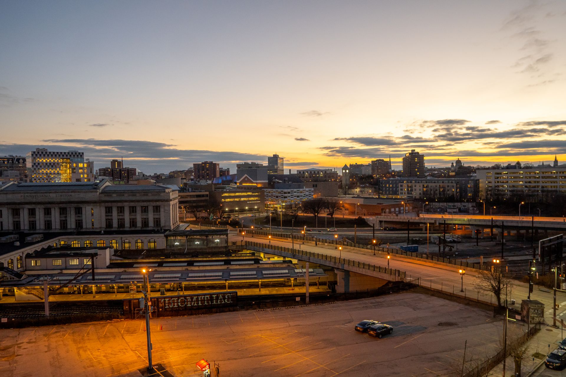 Aerial view of Baltimore cityscape at dusk, showcasing urban architecture and illuminated streets.